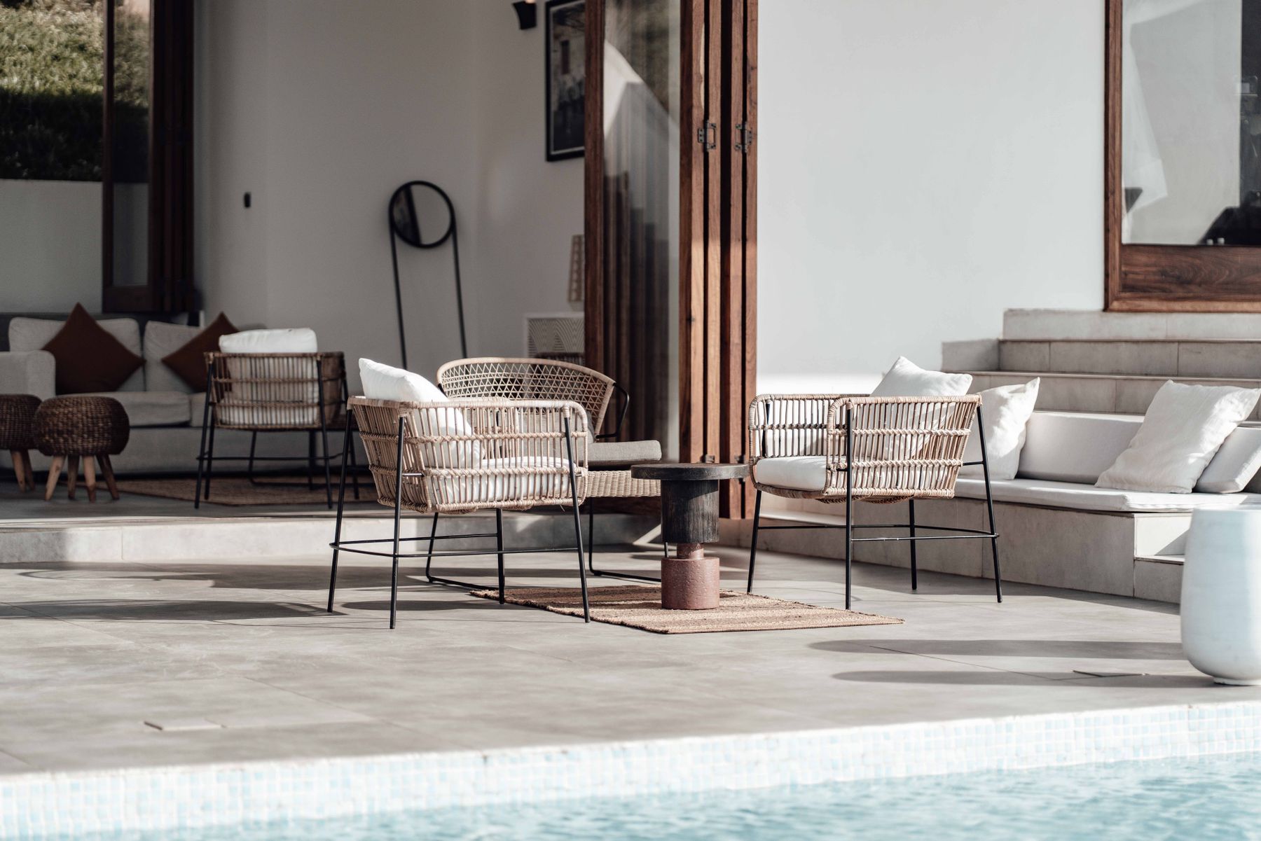 The finished terrace: reclaimed teak, woven chairs and a low table set against the garden.